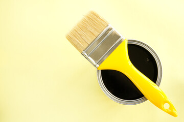 Paint brush with black paint on yellow background