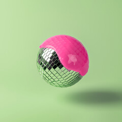 Mirror disco ball draped in bright pink paint, hovering over a pastel green backdrop, blending...