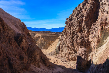 A rocky canyon with a blue sky in the background