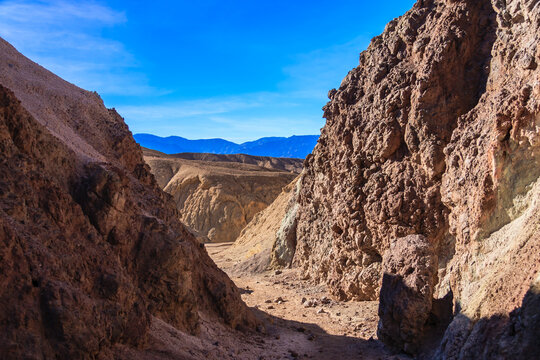 A rocky canyon with a blue sky in the background