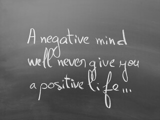 Inspirational quote handwritten on a chalkboard: 'a negative mind will never give you a positive...