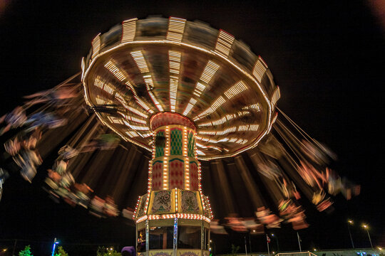 A carnival ride is spinning in the dark