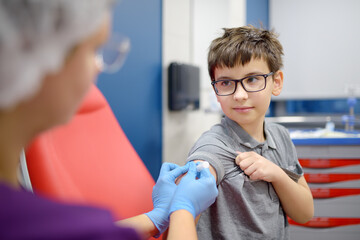 A boy is being vaccinated. A child is given a vaccine during an epidemic or outbreak of a disease.