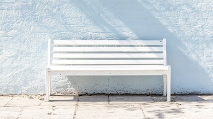 A simple white wooden bench positioned on the street, offering a peaceful spot for rest. High-resolution image for versatile use