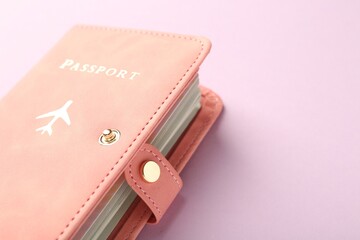 Passport in pink cover on violet background, closeup. Space for text