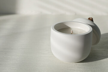 Soy candle and lid on white wooden table, space for text