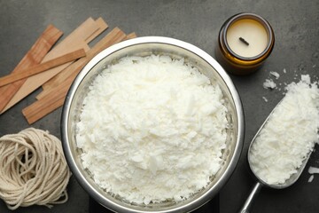Soy wax and other supplies for making candles on grey table, flat lay