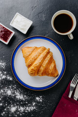 Classic croissant with jam, cream, and coffee for a perfect breakfast treat