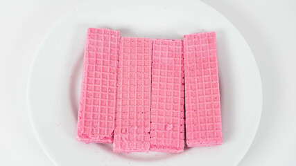 Colorful pink wafers arranged on a white plate