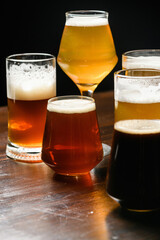 Variety of beer glasses with different types of beer on wooden table. Close-up.