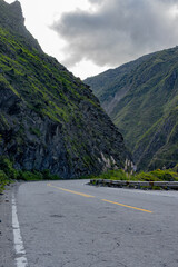 Carretera Curvada, Montañas Imponentes, Cielo Nublado, Aventura en el Horizonte