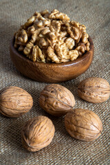 Peel walnuts and whole walnuts in wooden bowl,top view 