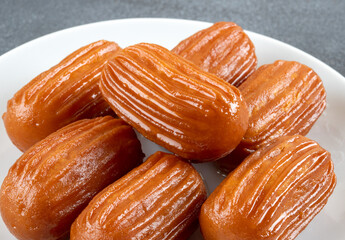 Traditional Turkish dessert tulumba on a plate. Tulumba dessert, fried in oil and soaked in syrup