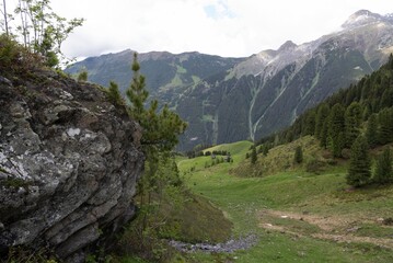 Dramatic Rock Formation Overlooking Alpine Valley with Rolling Meadows in Zillertal, Tirol, Austria