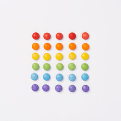Brightly coloured sweets on white background. Rainbow colored candy. Happiness and cheerfulness concept