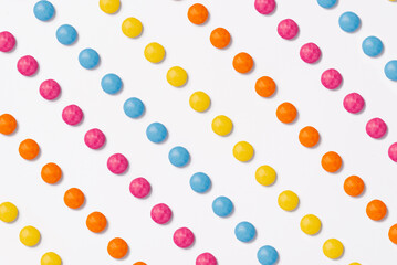 Brightly coloured sweets on white background. Rainbow colored candy. Happiness and cheerfulness concept