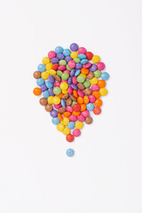 Brightly coloured sweets on white background. Rainbow colored candy. Happiness and cheerfulness concept