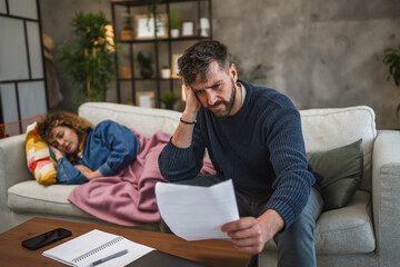 Obraz premium serious adult man work from home and check information from document