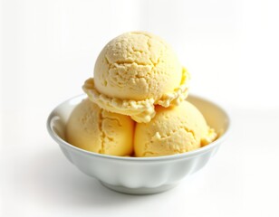 Close-up view of three scoops of vanilla ice cream. Ice cream scoops piled in small white bowl. Bowl slightly scalloped edge. Ice cream looks creamy, smooth with slightly textured surface. Presented