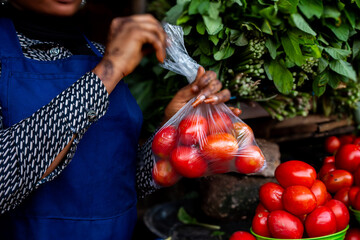 Young African market woman selling tomatoes giving thumbs up