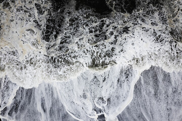 Aerial drone view of epic ocean waves crashing on the shoreline black beach Reynisfjara in Iceland in VIK Myrdal in Golden Circle Area
