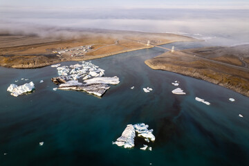 Aerial drone View of icebergs floating by a coastal bridge and road in Jokulsarlon Glacier Lagoon in Iceland