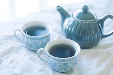 Fototapeta premium Serene Morning Tea, Blue Teacups and Teapot on White Linen