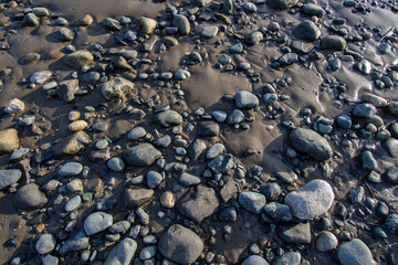 Rocks and pebbles in the sand at the beach