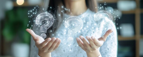 Fototapeta premium Businesswoman holding glowing question marks in her hands