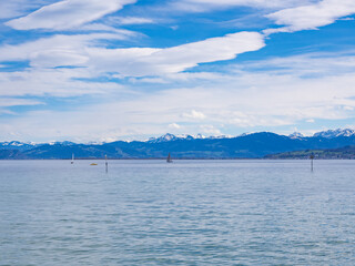 Arbon, Switzerland - March 29th 2024: Lake Constance in front of the Alps with typical Foehn clouds
