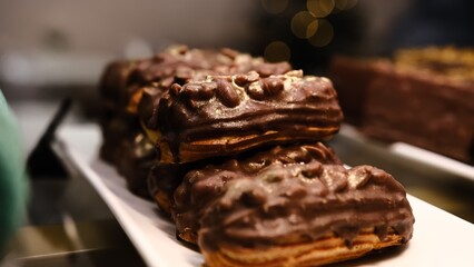 A delicious gourmet eclair filled with creamy custard, topped with crunchy peanuts, rich chocolate...