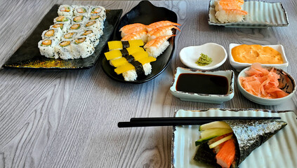 Sushi and rolls set with wasabi and soy sauce on wooden table