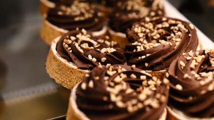 chocolate tart crushed peanut topping in buttery shortcrust pastry basket on white plate placed on counter perfect for dessert lovers indulgent treat rich texture sweet pastry close up festive