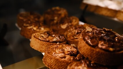 Beautiful nut tart covered glaze in shortcrust pastry shell on white plate displayed on counter fresh delicious dessert perfect for holidays parties and celebrations indulgent sweet treat with nuts