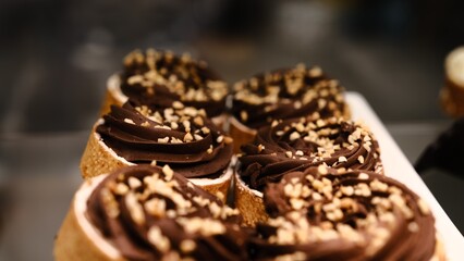 chocolate tart crushed peanut topping in buttery shortcrust pastry basket on white plate placed on counter perfect for dessert lovers indulgent treat rich texture sweet pastry close up festive