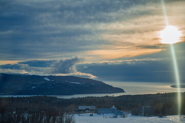 Beautiful winter landscape with snow covered trees and mountains at sunset.