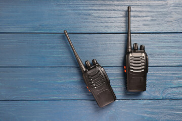 Walkie talkies on blue wooden table, top view. Space for text