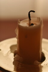 An extinguished candle in a beautiful candlestick