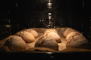 Brötchen auf Backpapier im Backofen