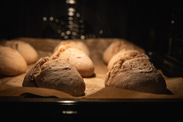 Brötchen auf Backpapier im Backofen