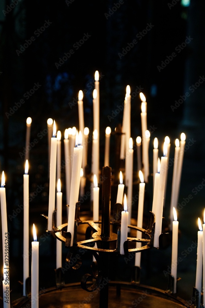 Poster a serene collection of flickering candles illuminating a dark background, casting warm glows that cr