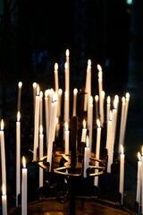 A serene collection of flickering candles illuminating a dark background, casting warm glows that...