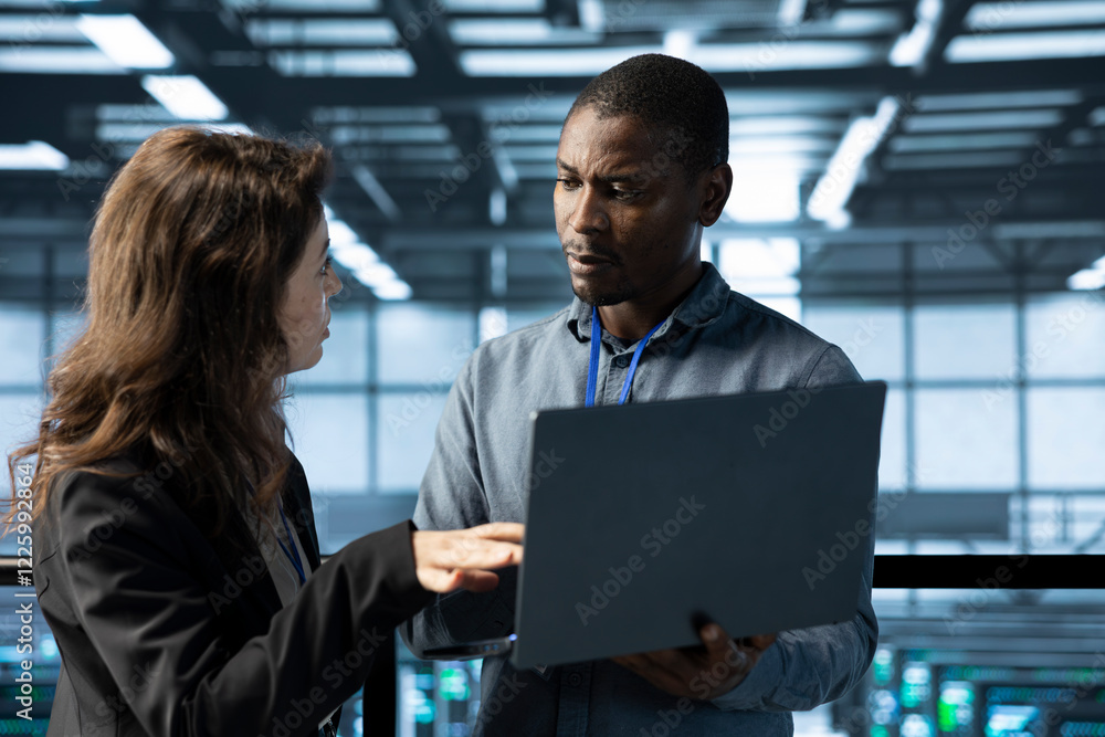Poster system administrators in data center using laptop, analyzing metrics, optimizing storage volumes. se