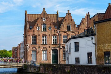 A scenic view of the tranquil canal in Bruges, Belgium, lined with colorful medieval buildings and quaint bridges, capturing the essence of this charming city rich in history and culture.
