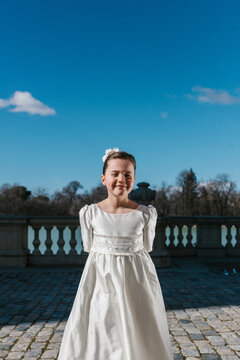 Young Girl in First Communion Dress Posing Outdoors
