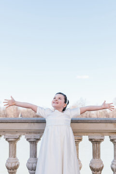 Joyful girl celebrating First Communion in elegant dress