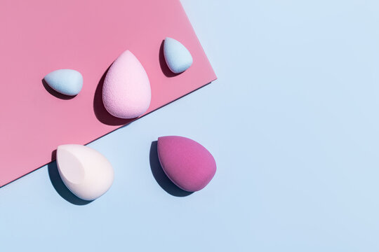 Array of colorful makeup sponges on a dual-tone background