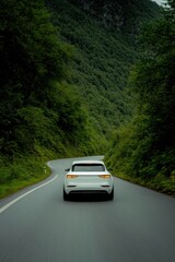 white electric suv cruising through mountain road surrounded by lush green trees with light streaks and motion blur