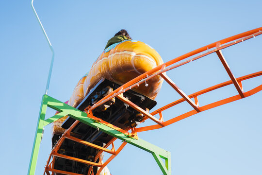 Thrilling roller coaster ride on vivid track under blue sky