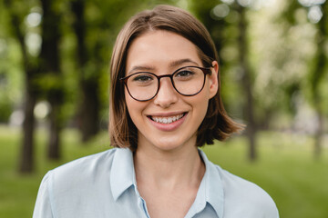 Close up portrait of a young smart caucasian woman female student teenager wearing glasses walking...